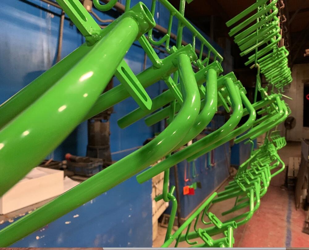 Green fabricated tube parts hanging on the finishing line in the Bushnell shop